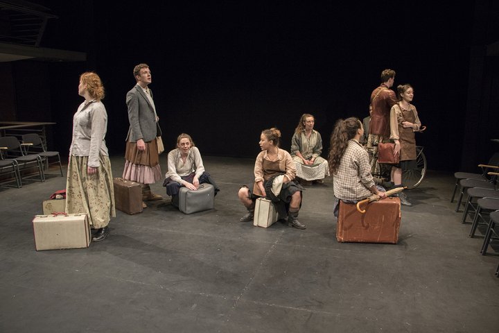 RADA acting students with suitcases in a scene from a Shakespeare Schools tour performance