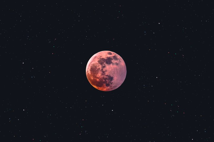 A red moon in the middle of a black sky