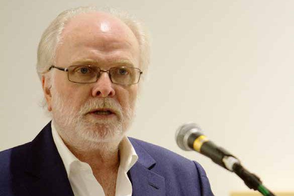 Michael Attenborough speaks into a microphone at a lectern