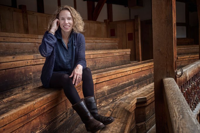 Michelle Terry sits in the wooden benches at the Globe Theatre