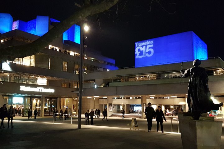 the National Theatre lit up at night with statue of Laurence Olivier